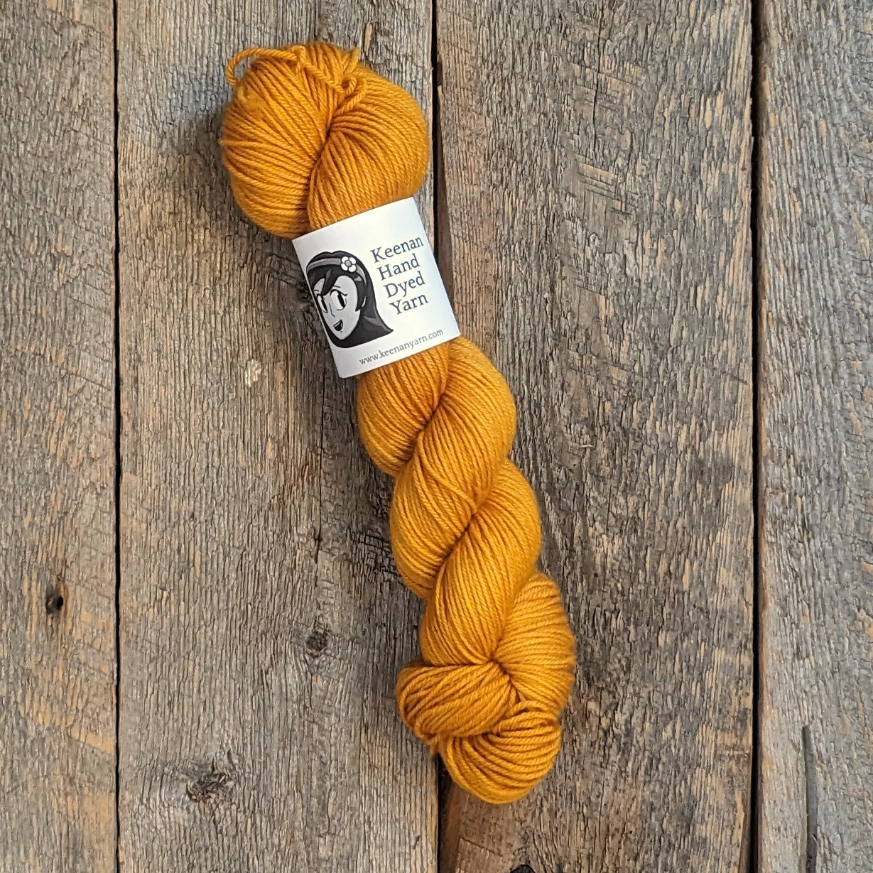 Golden yellow Bluefaced Leicester DK yarn on a wood background