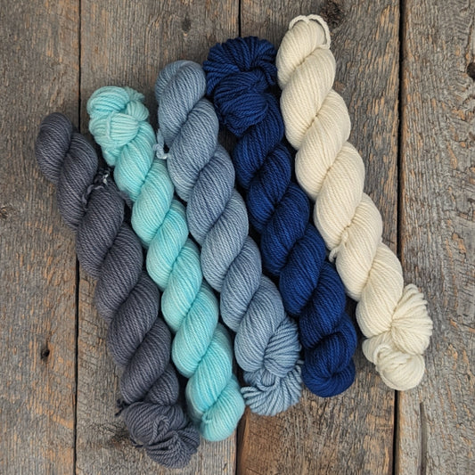 5-50 gram skeins of 100% Targhee DK wool in gray, sky blue, gray-blue, royal blue, and natural