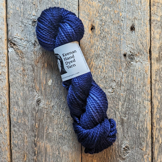 dark blue bulky superwash Merino wool yarn on a wooden background